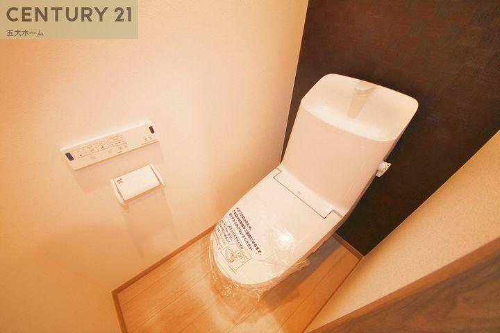 トイレ シャワートイレ一体型でオールシーズン関係なく暖かい便座で快適に過ごせます。収納棚を設けることで小物やトイレットペーパーなどが目につかない状態で収納できます。（1号棟）