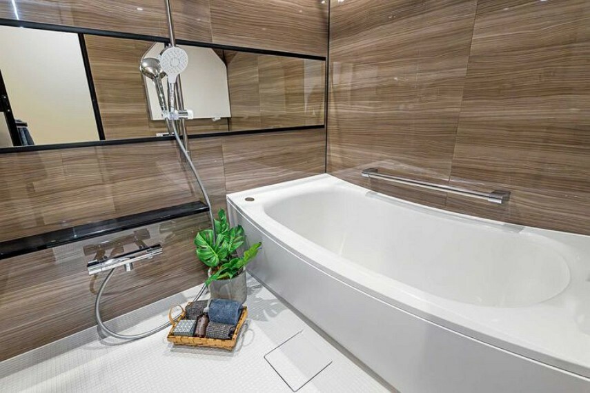 浴室 美しいカーブと全身を包み込むような入浴感が特長の浴槽や光沢感のある木目調パネルによって、より一層くつろぎの空間が演出されるバスルームです。