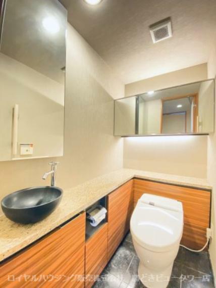 トイレ 天然石仕様の床材、タンクレス・手洗いカウンター付きトイレ