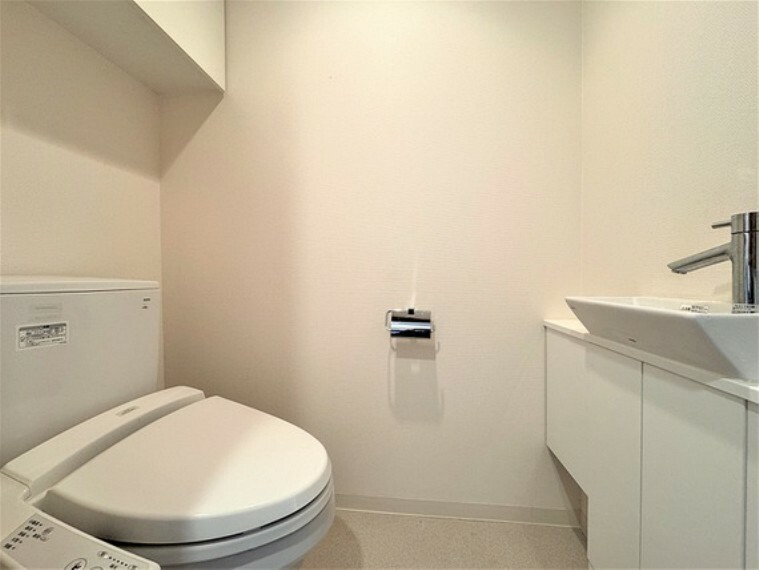 トイレ 清潔を保てる、温水洗浄便座・手洗い器付きのトイレです。シンプルな雰囲気で落ち着きを感じさせます。