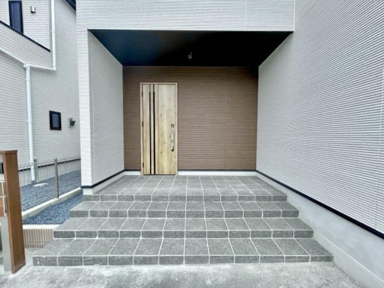 玄関 【2号棟】玄関部分はアクセントで外壁色を変え、木目の玄関ドアを使うことによりスタイリッシュなデザインです。