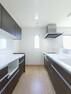 キッチン キッチン背面にキッチンと同色の面材を使用したカップボードを設置し、収納力と統一感を高めています。