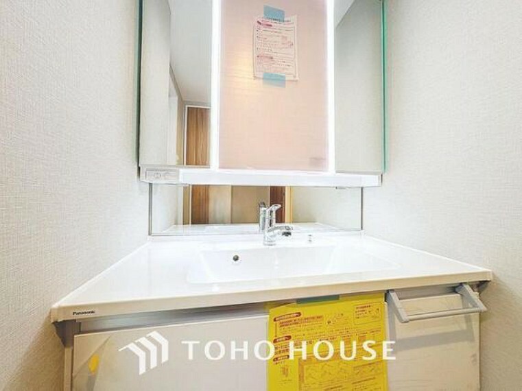 洗面化粧台 「清潔な印象の洗面室」明るく清潔感のある色調で纏められた洗面室は、機能性に富んだ三面鏡と使い勝手の良い収納を完備した洗面台を設置。洗濯機置場も完備し、大変充実しております。