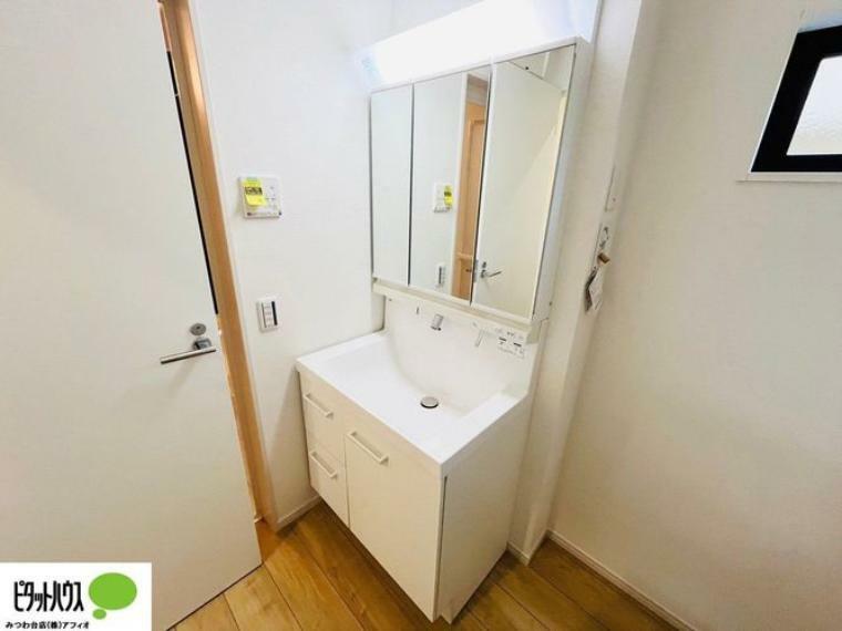 施工例写真:シャワー付き三面鏡洗面台。便利な収納棚でタオルや小物がスッキリ。