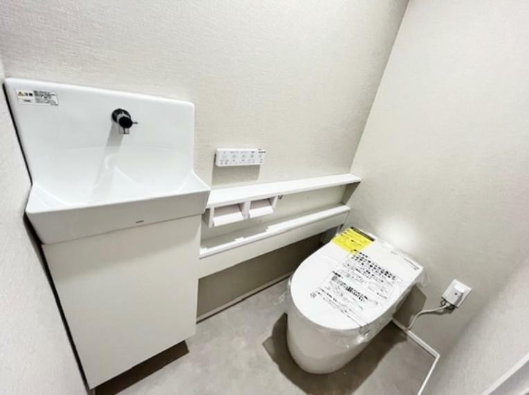 トイレ 空間と調和するタンクレストイレ。その場ですぐに手を洗える手洗いカウンター付。