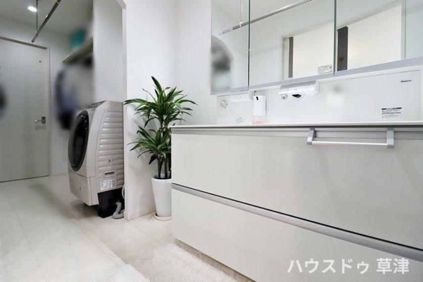 洗面化粧台 三面鏡の裏に収納が豊富なドレッサーは、家族各々の物をキチンと収納し、すっきり清潔に保てます。横にはランドリーコーナーがあり洗濯物を干すことができるスペースもあります。