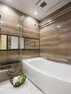 浴室 毎日のバスタイムを贅沢に、豊かにしてくれるバスルームです。光沢のある木目調のパネルが、より一層くつろぎの空間へ誘います。