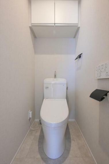 トイレ 白を基調にした清潔感のあるトイレには、便利な吊戸棚を設置