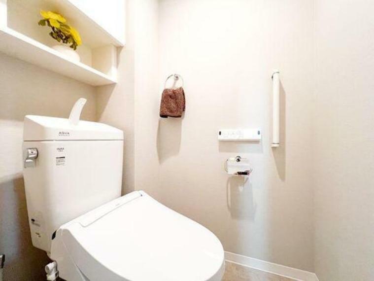 白を基調としたトイレは、清潔感がございます。収納棚もございます。