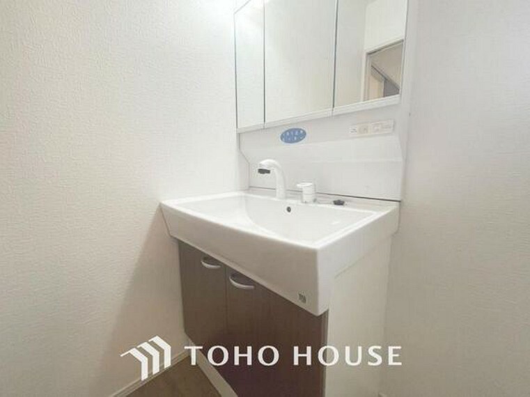 洗面化粧台 「シャワー機能付き。三面鏡洗面台」洗面台には三面鏡を採用。鏡の後ろに収納スペースが設けられているので、洗面台周りをスッキリと片付ける事ができます。
