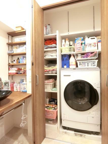 洗面化粧台 ドラム式洗濯機も設置可能な洗濯機置場と収納力のあるリネンスペース。