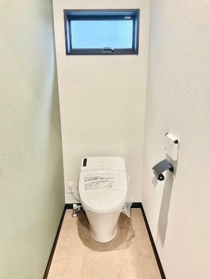 トイレ ネイビーのペーパーホルダーがアクセントのタンクレストイレ。