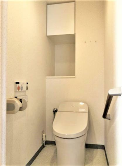 タンクレスタイプのウォシュレット一体型トイレ。吊戸棚やニッチ付き。