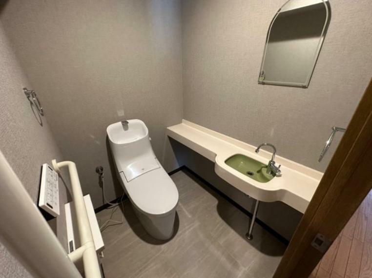 トイレ シンプルで機能的なミニ手洗い場付きカウンターのあるトイレ