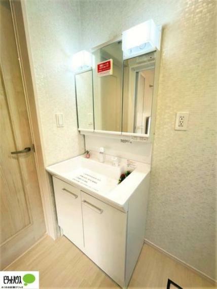 洗面化粧台 施工例写真　使い勝手のいい三面鏡。24時間換気の換気扇と窓があり清潔感のある洗面室です。