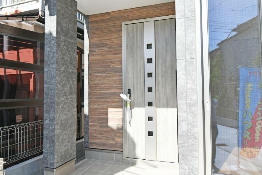 玄関 現地写真（家の顔となる玄関ドアはエッジの効いた現代風デザイン。高級感と断熱性、防犯性に優れた玄関ドア採用）