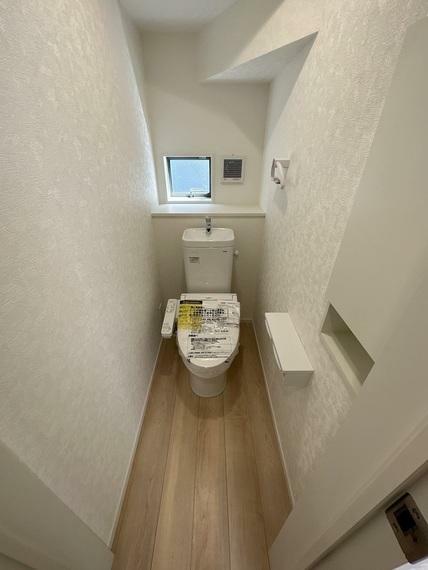 1階　トイレ　換気扇、窓、タオル掛け、温水暖房便座付きのトイレです