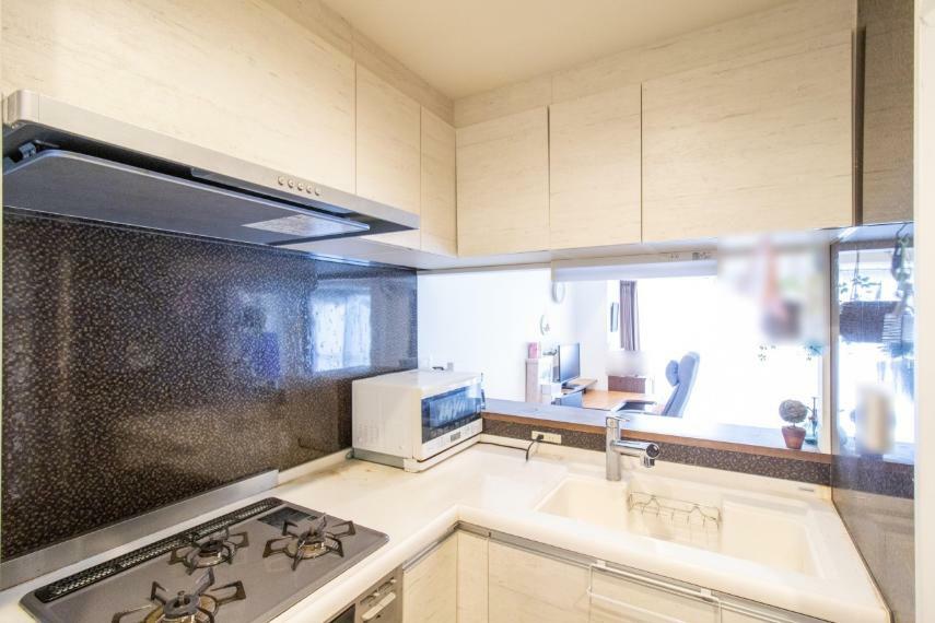 ダイニングキッチン L字型のキッチンは、限られた空間の中で最大限の作業スペースを確保する工夫の成果です。吊戸棚も含めて多めに収納を確保。使い勝手の良いキッチンになっています。