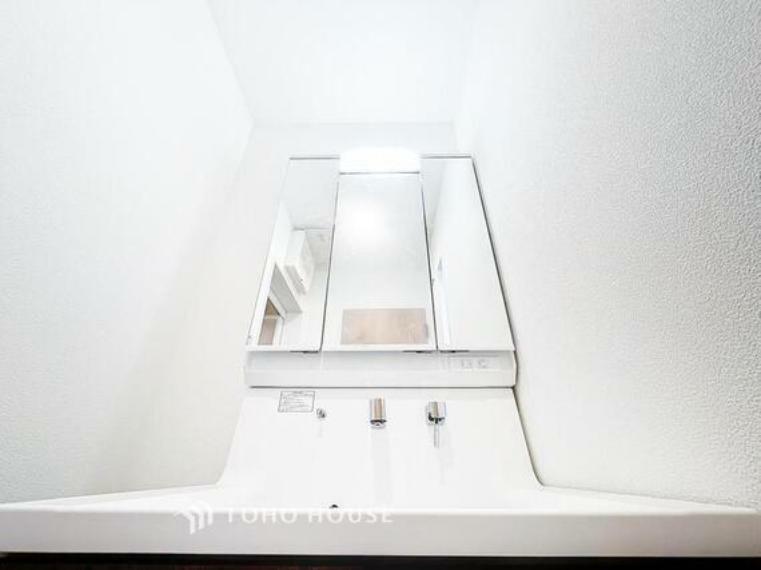 「シャワー機能付き。三面鏡洗面台」洗面台には三面鏡を採用。鏡の後ろに収納スペースが設けられているので、洗面台周りをスッキリと片付ける事ができます。