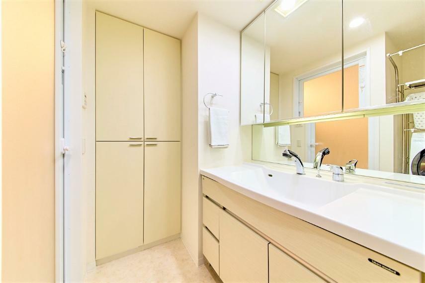 3面鏡付き洗面化粧台を備えた洗面室には両開きのリネン庫も完備