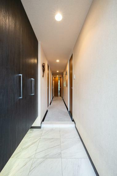 大理石仕様の床とシックなデザインの玄関下足入れ