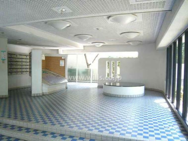 白とブルーの市松模様の床タイルが印象的なエントランスホール