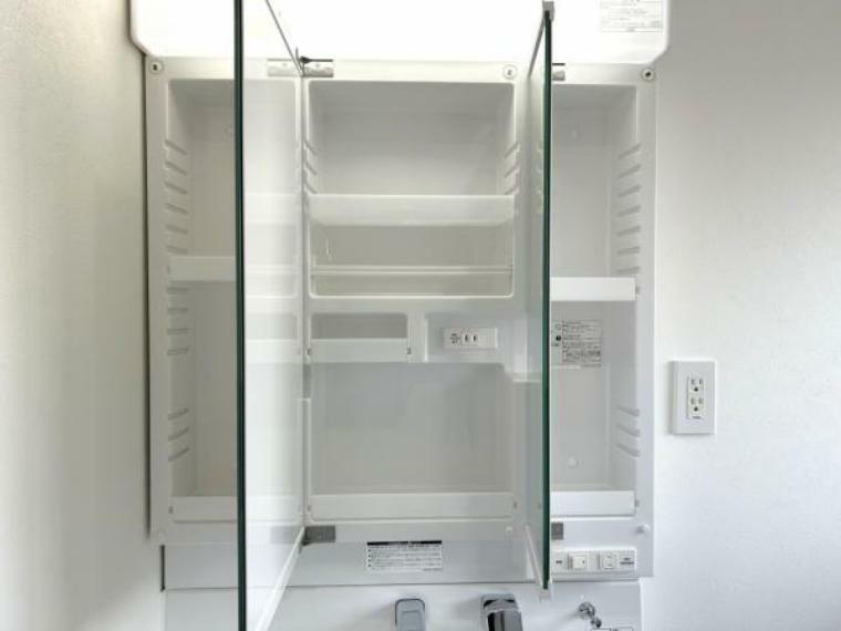 【リフォーム済】洗面台の鏡は三面鏡タイプで内部が収納棚になっています。収納の内部にコンセントがあるので電動歯ブラシや電気シェーバーなどは充電したまま収納することができます。