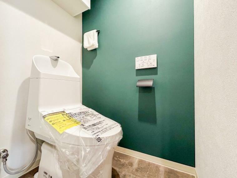 トイレ 緑の壁紙が映える清潔感あるトイレです。上部に小物収納がございます。