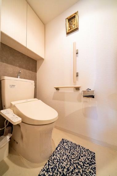 トイレ 快適な温水洗浄便座付きのトイレ。モルタル調のアクセントクロスが、落ち着きを感じる空間を演出します。