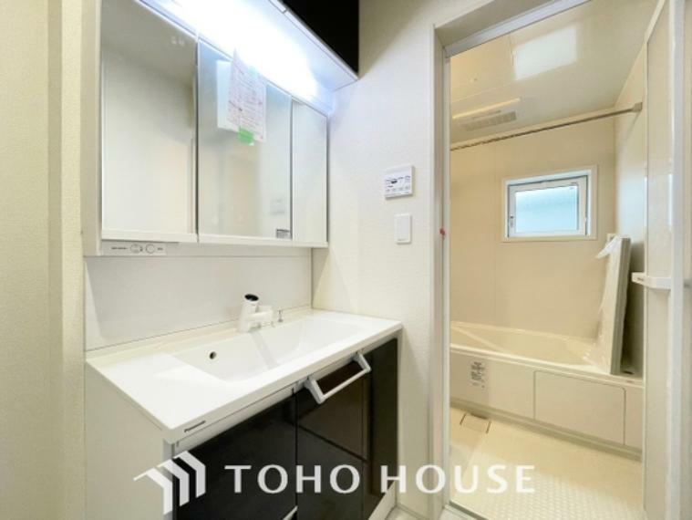 洗面化粧台 「洗面所」明るく清潔感のある色調で纏められた洗面室は、機能性に富んだ三面鏡と使い勝手の良い収納を完備した洗面台を設置しております。