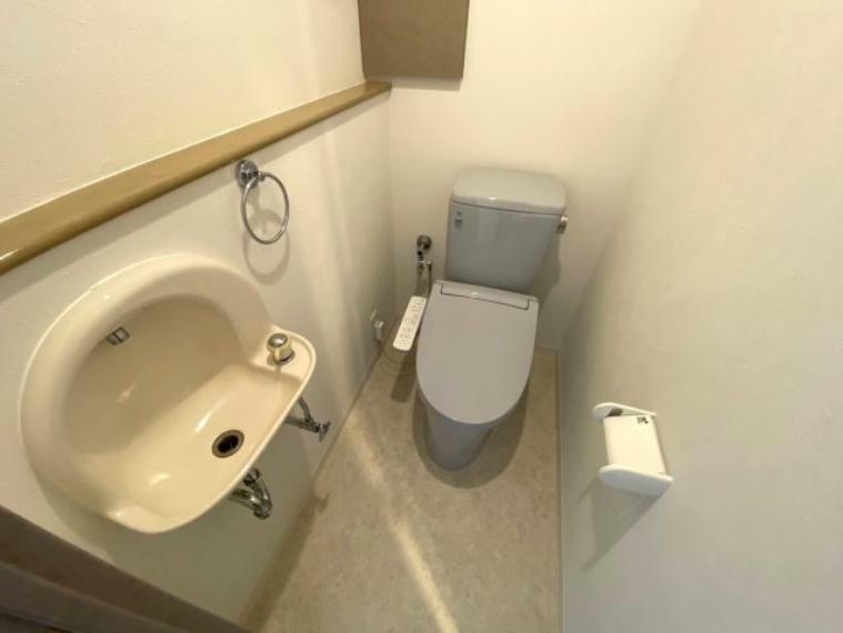 トイレ シンプルで機能的なミニ手洗い場付カウンターのあるトイレ。ウォシュレット付。