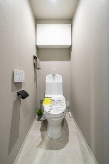 トイレ 清潔感溢れるホワイト基調のレストルームです。上部吊戸棚収納が備わっているため、掃除用品やペーパー類もすっきりと収納可能です。