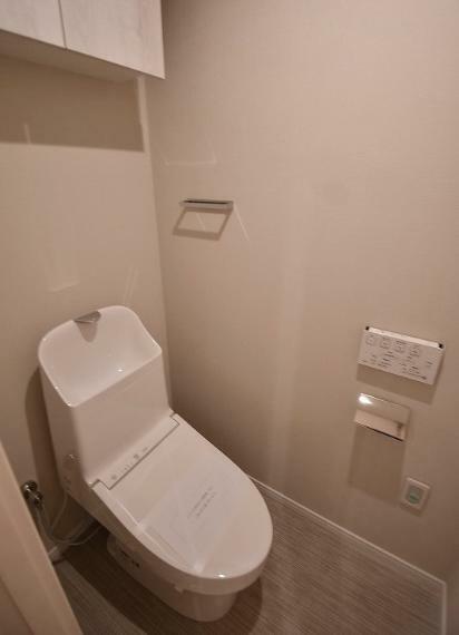 清潔感のあるトイレは洗浄機能付。上部に吊戸収納があります。