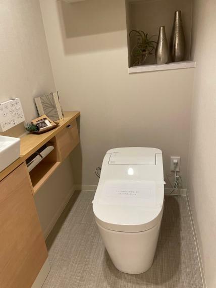 トイレ 洗面所と収納を兼ねた白を基調としたトイレ。
