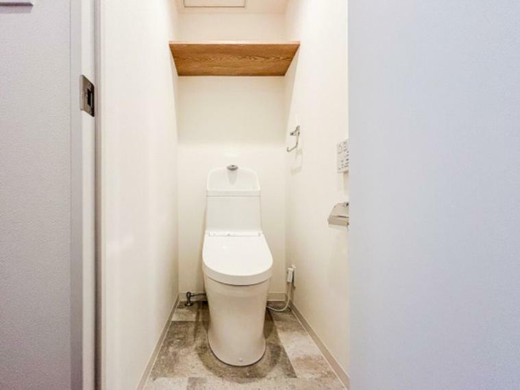 トイレ 清潔感あふれるウォッシュレット付きのトイレです。上部木目の棚がワンポイントです。