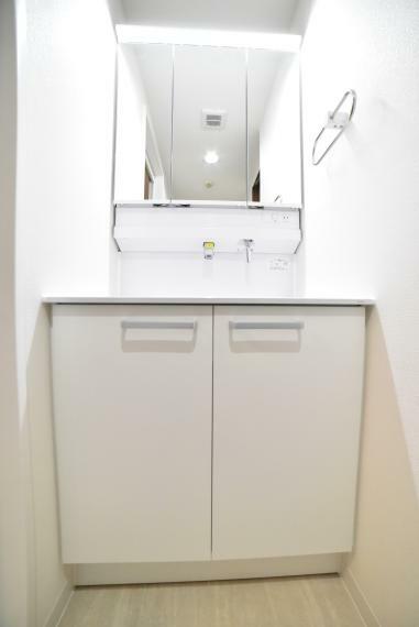 洗面化粧台 《同社施工例》洗面台には三面鏡を採用。収納スペースを設ける事により、散らかりやすい洗面スペースをすっきりさせることができます。