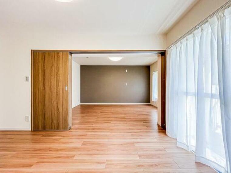 居間・リビング 洋室の引き戸を開けると、リビングと繋がる開放的な空間が広がります。
