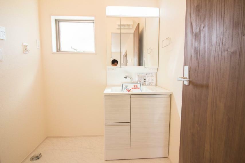 洗面化粧台 明るい清潔感のある洗面所は、鏡も大きくシンクが広々。朝の支度も楽にこなせます。