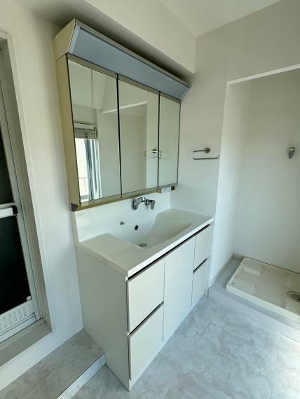 洗面化粧台 大きく見やすい三面鏡で清潔感ある洗面台は、身だしなみチェックや肌のお手入れに最適です。 何かとに物が増える場所だからこそ、スッキリと見映えの良い空間に拵えました。