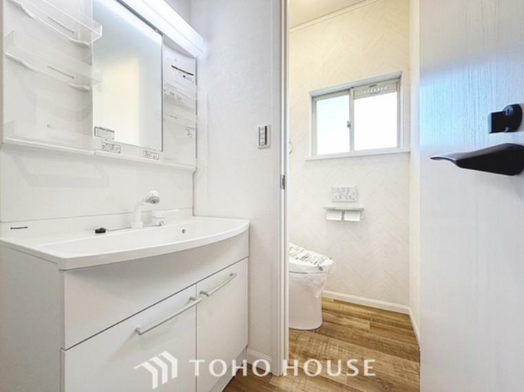 脱衣場 シャワー機能付きの洗面台には使いやすい横長ボウル、スマートに収まる収納と充実しています。