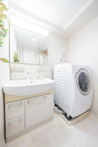 清潔感のあるホワイトカラーでコーディネートした洗面室。身だしなみのチェックがしやすい大きな3面鏡。収納力も豊富で、スッキリとした空間です