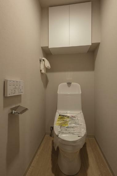 トイレ 吊戸棚付きで備品や掃除用品の収納が可能。