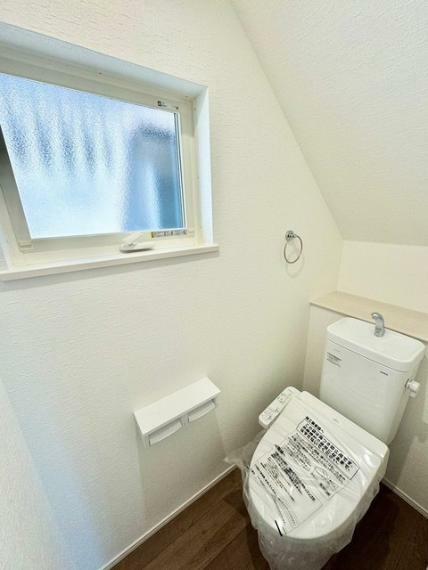 トイレ 小窓付きトイレ。温水洗浄便座も完備し、清潔で快適な空間を提供します。自然光が差し込み、心地よい時間を。