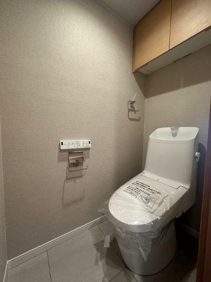 トイレ 快適にお使いいただける温水洗浄便座付トイレです。吊戸棚が付いているので収納にも困りません。