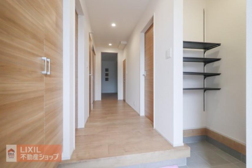 【玄関】現地完成写真。ゆったりと明るい玄関がご家族や来客をお出迎え。下駄箱のほか可動棚付きの土間収納があります。