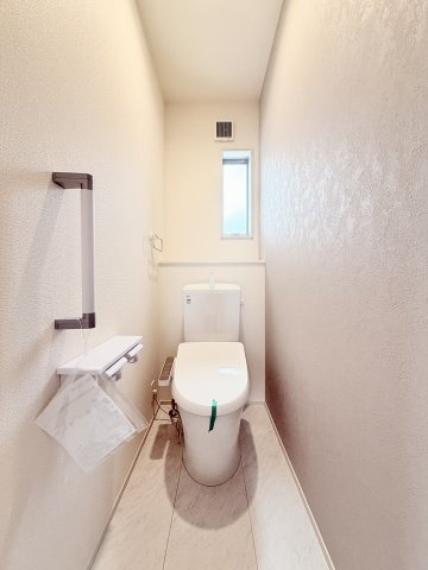 窓の付いた清潔感と明るさのあるトイレ空間。手すり付きで、ご高齢の方でも安心してご使用いただけます。