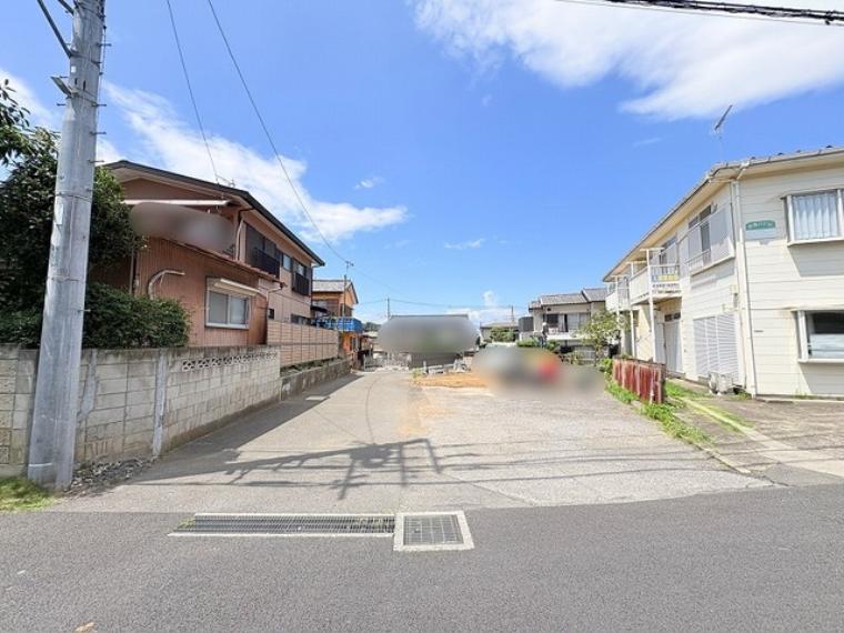 青い空が広がり、穏やかな時間が流れる落ち着いた住宅街の風景です。